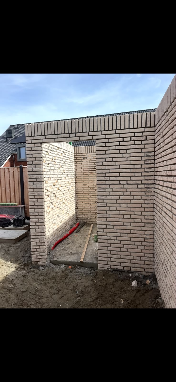 Deuropening in het metselwerk van de schuur, met rollaagafwerking bovenop de muren